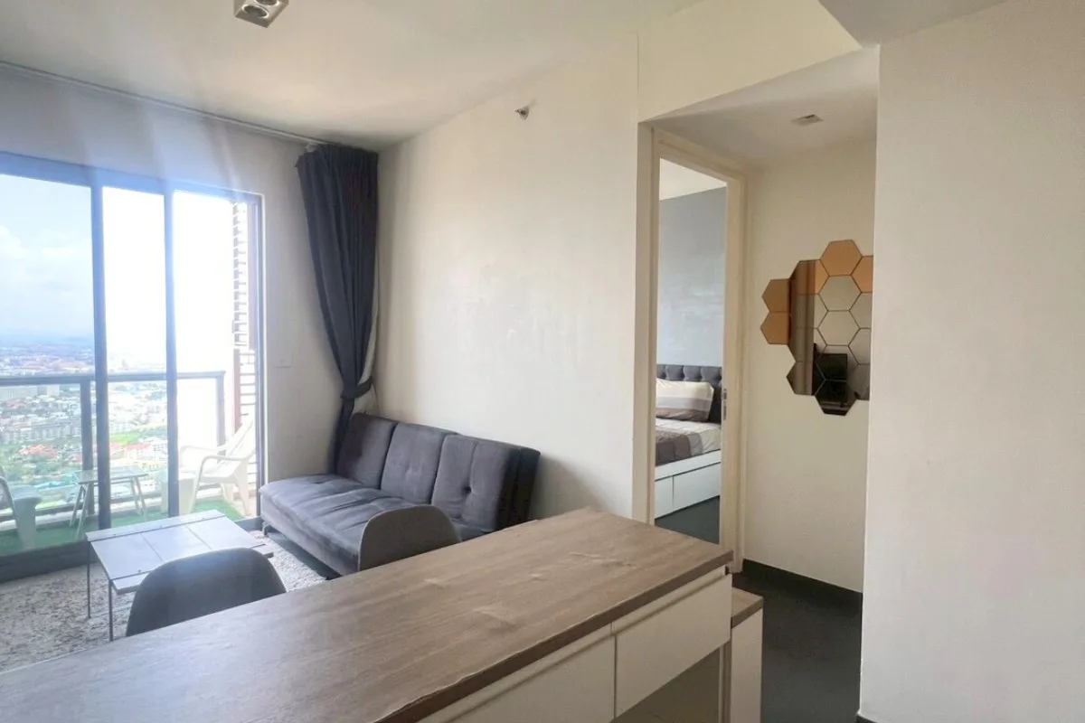 1 Bedroom Condo for Sale at Unixx South Pattaya: kitchen area with wooden cabinets, sink, refrigerator, and dining counter.