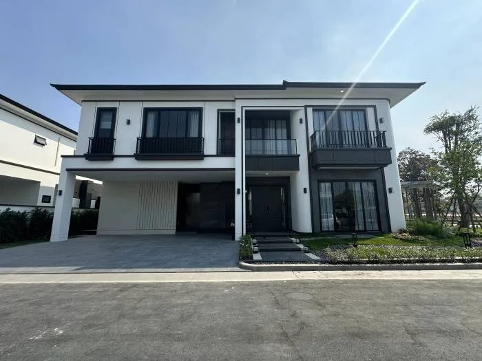 Chieftain modern white two-story house with black trim, large windows, balconies, and a swimming pool on the left.