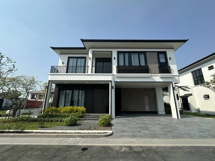 Chieftain modern two-story house with white facade, black trim, large windows, and a covered parking area.