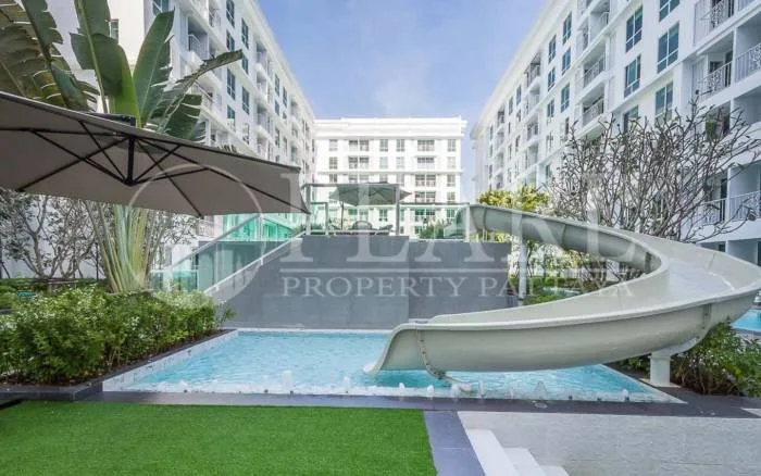 The Orient Resort & Spa outdoor swimming pool area with a water slide and surrounding lush greenery.