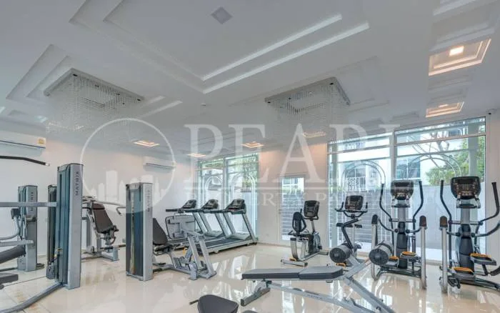 The Orient Resort & Spa elegant reception desk in the lobby with a large floral arrangement and seating area.